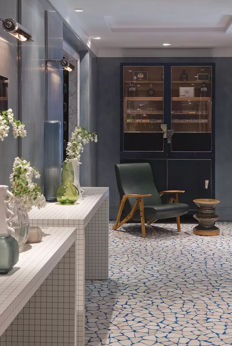 Ein stilvoll eingerichteter Raum mit Zanotta 6006 Teti Stuhl und dekorativen Vasen auf einem weißen Mosaiktisch Moodbild einer eleganten Inneneinrichtung