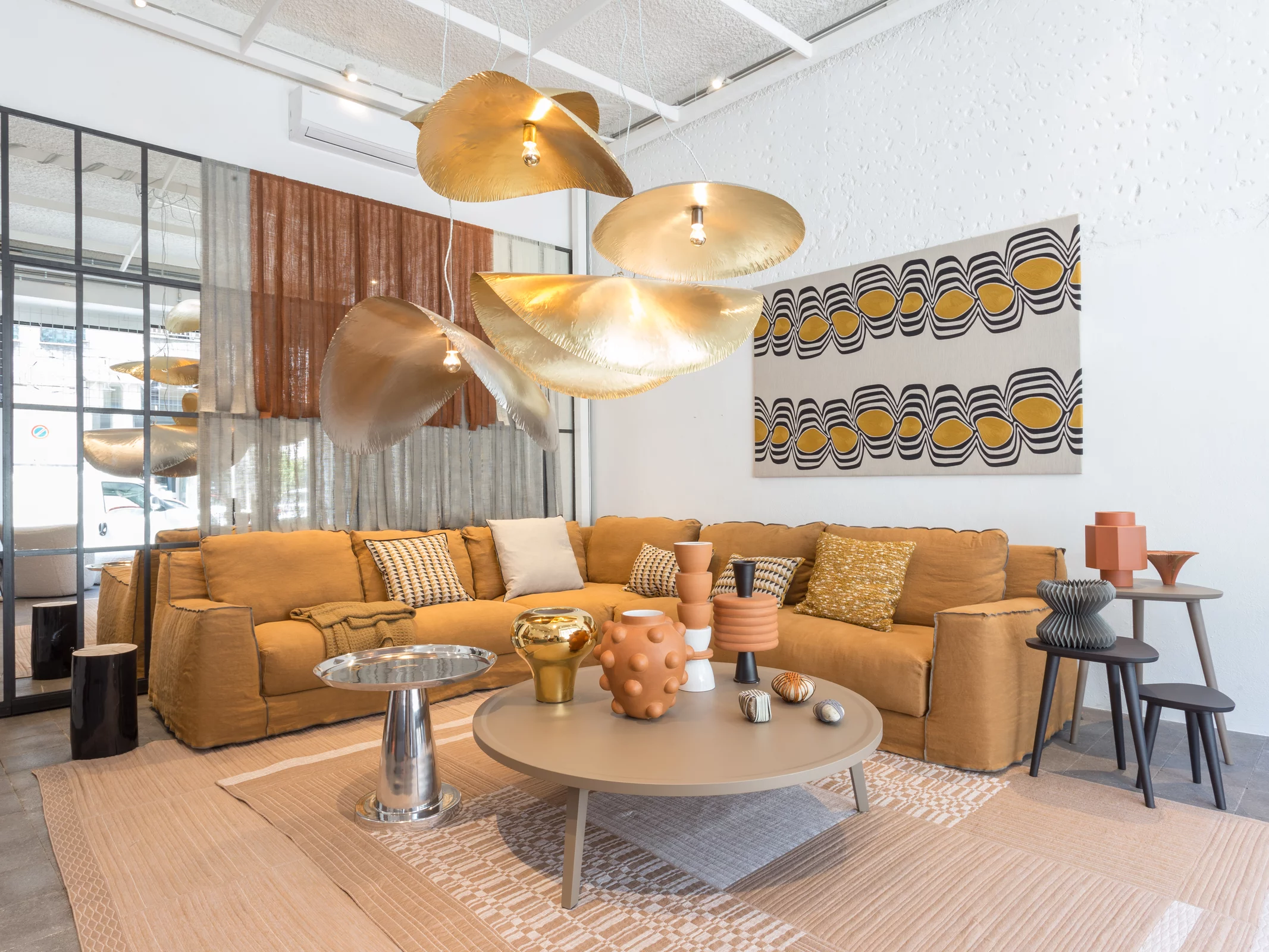 Gervasoni Wohnzimmer mit braunem Sofa und dekorativen Kissen in einem modern eingerichteten Raum mit Kunstwerken und stilvollen Lampen