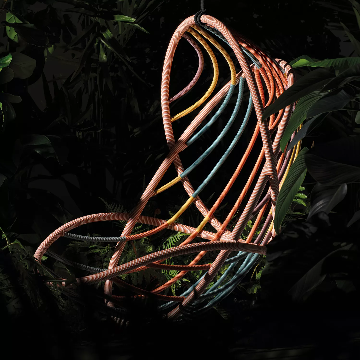 Dedon Kida Hängesessel in bunten Farben hängt in einem üppigen tropischen Garten