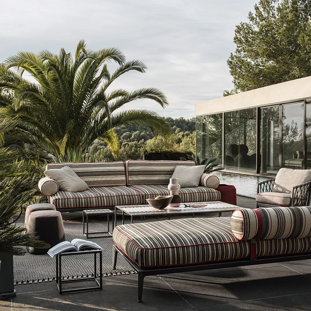 B&B Italia Frank Hocker in einer stilvollen Outdoor-Lounge mit modernen Möbeln und Palmen im Hintergrund