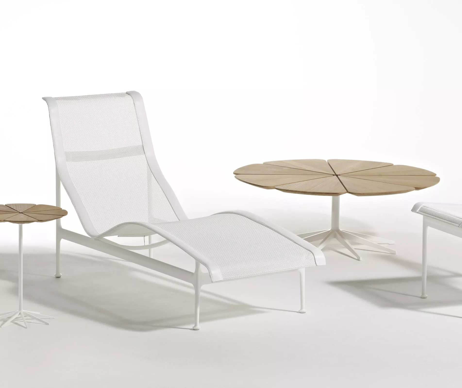 Knoll Studio Petal Beistelltisch 107 cm in einem minimalistischen Raum mit einer weißen Liege und einem kleineren Beistelltisch ohne Hintergrund