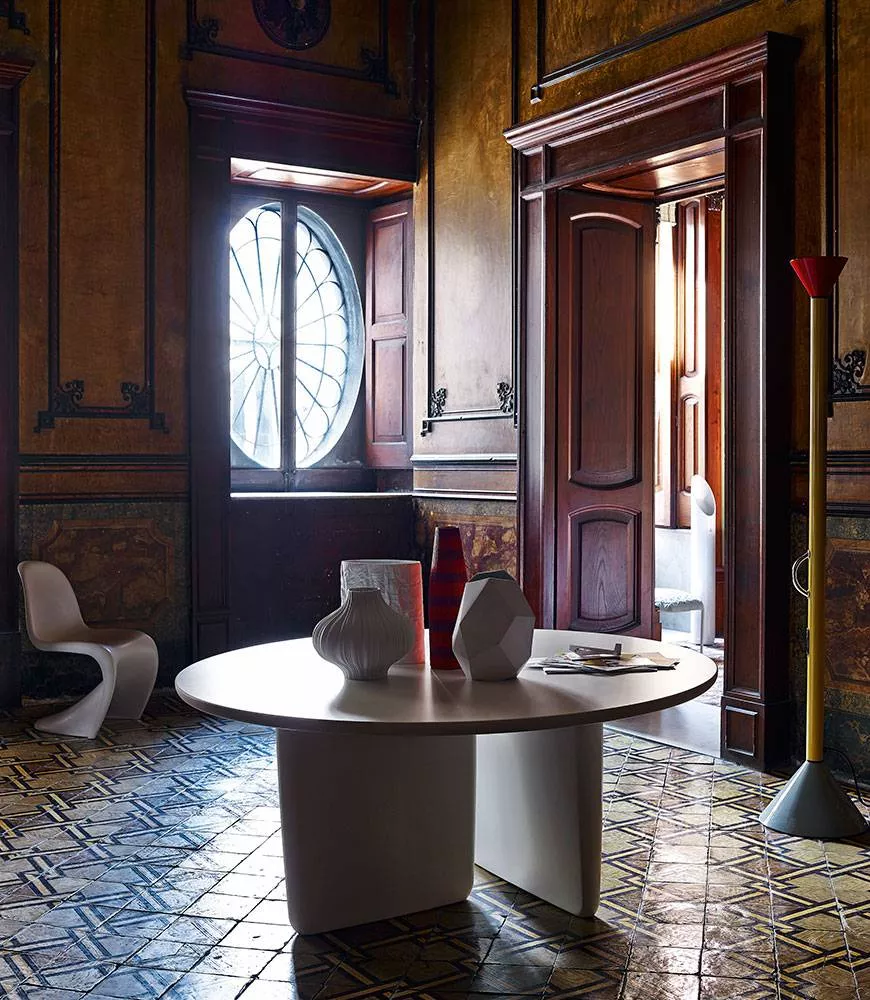 B&B Italia Tobi Ishi Tisch in einem stilvollen Raum mit antiken Holztüren und einem großen Fenster im Hintergrund