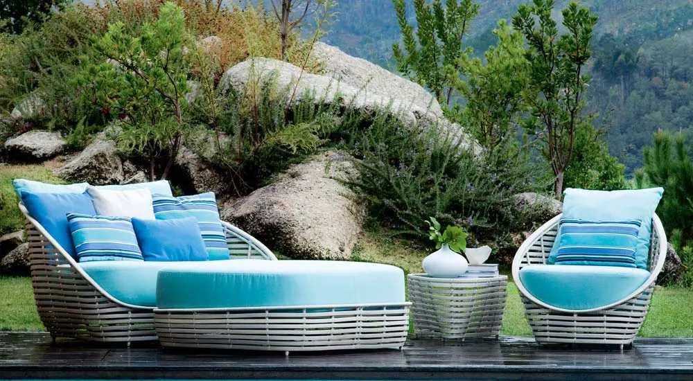Kenneth Cobonpue Oasis Loungegruppe in Weiß und Blau vor einer natürlichen Fels- und Pflanzenkulisse im Freien.