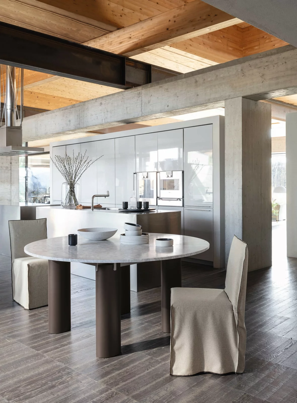 Gervasoni Tisch und Stühle in modernem Esszimmer mit offener Küche und Holzdecke