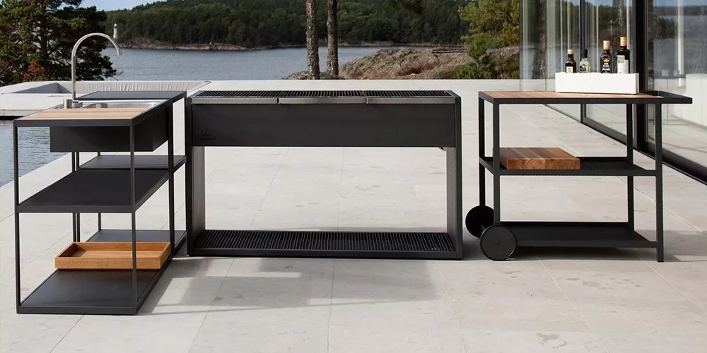 Roshults Open Kitchen in Schwarz auf einer Terrasse mit Seeblick, bestehend aus Grill, Spüle und Servierwagen, modernes Design.