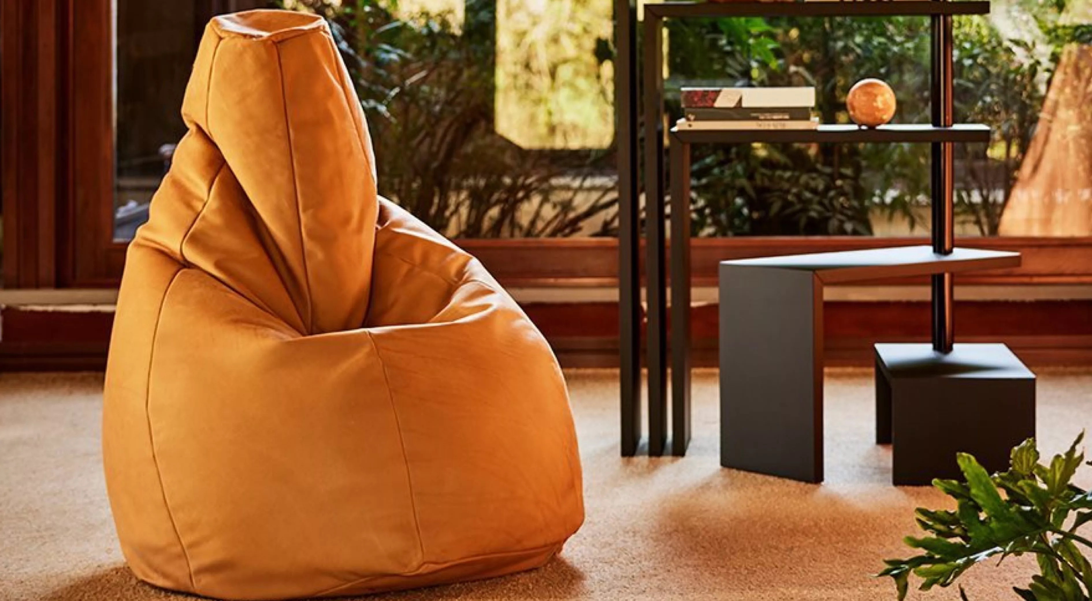 Ein gelber Sacco-Sitzsack von Zanotta in einem gemütlichen Wohnzimmer mit Teppichboden und Blick auf einen modernen Beistelltisch.