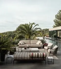B&B Italia Ribes Outdoor Lounge auf einer Terrasse mit Palmen und Pool im Hintergrund