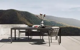 Solpuri Classic Alu Tisch und Stühle auf einer Terrasse mit Bergblick und gedecktem Tisch mit Vase und Obstkorb Moodbild