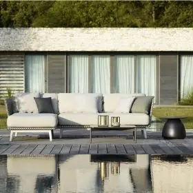 Dedon Mbarq Lounge in einem modernen Garten mit Pool im Vordergrund und einem stilvollen Haus im Hintergrund 