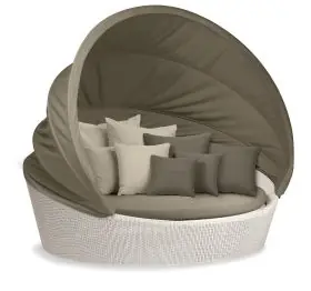 Dedon Orbit XXL Sofainsel in einem Garten mit mehreren Kissen und einem schützenden Baldachin für komfortable Outdoor-Entspannung.