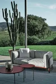B&B Italia Borea Loungesofa steht draußen auf einer Terrasse mit Blick auf einen Garten mit einem Kaktus und einem Baum im Hintergrund
