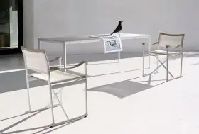 B&B Italia Mirto Outdoor Essgruppe bestehend aus einem weißen Tisch und zwei weißen Stühlen mit einem Vogeldekor auf dem Tisch in einer minimalistischen Umgebung